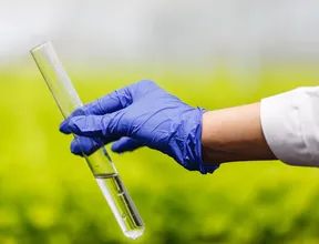 researcher-holds-test-tube-with-water-hand-blue-glove